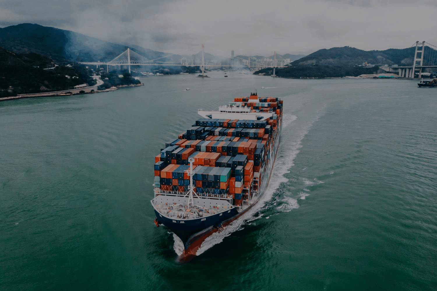 Large cargo ship loaded with containers sailing on water, representing global shipping and logistics.