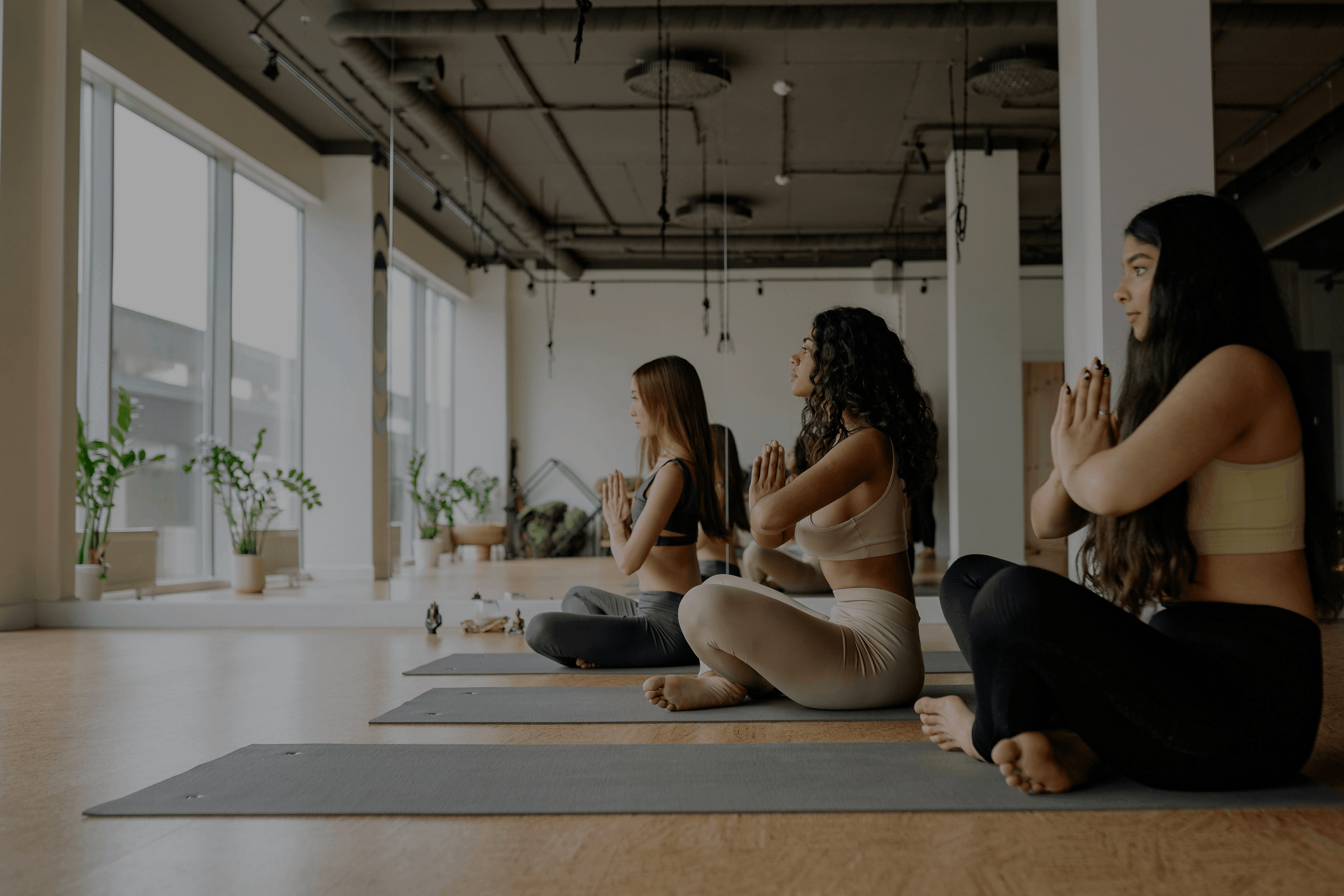 Group of people practicing yoga in a modern indoor studio, symbolizing wellness and lifestyle.
